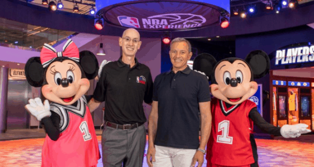 Guests join Minnie and Mickey Mouse, both sporting basketball jerseys, for a fun photo op at NBA Experience in Disney World.