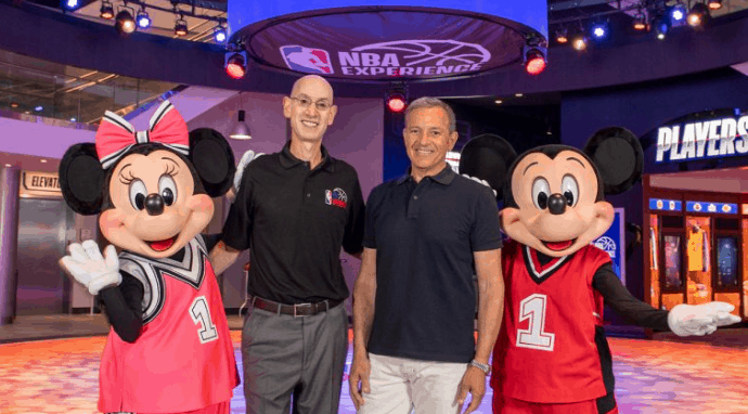 Guests join Minnie and Mickey Mouse, both sporting basketball jerseys, for a fun photo op at NBA Experience in Disney World.