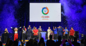 Mickey Mouse joins athletes on stage at Disney World for the 2022 Special Olympics USA Games, with confetti filling the air.
