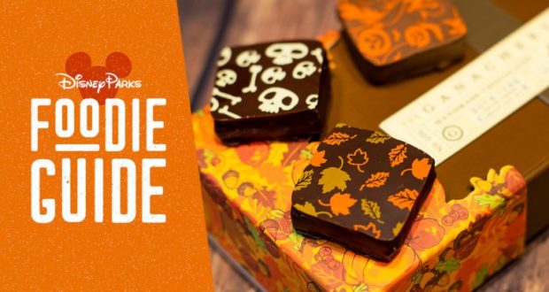 WonderFall Flavors at Disney Springs: three festive chocolate squares atop a fall box beside the Disney Parks Foodie Guide sign.