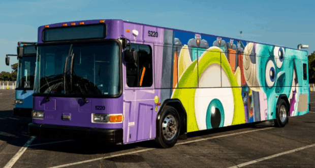 Monsters, Inc.-themed purple Disney bus parked under sunny skies at Walt Disney World, showcasing the resort’s playful fleet.