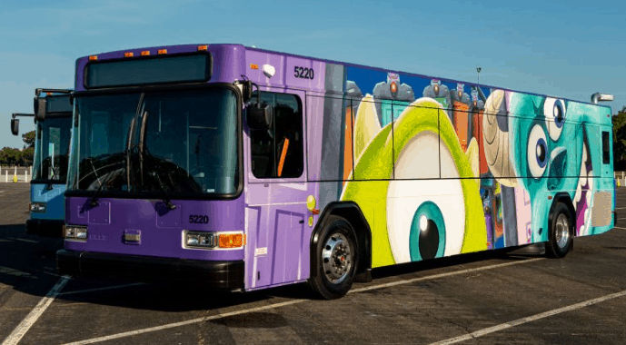 Monsters, Inc.-themed purple Disney bus parked under sunny skies at Walt Disney World, showcasing the resort’s playful fleet.