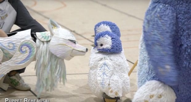A wolf puppet faces off with two fluffy blue-and-white penguin puppets during Holiday Creations rehearsal at Animal Kingdom.