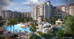 Riviera Resort features tall towers, a sunny pool with waterslide, palm trees, and sunbathers—just steps from Disney World.