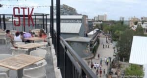 Guests enjoy dinner on STK Orlando’s rooftop, with lively Disney Springs views in the heart of Walt Disney World.