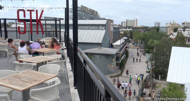 Guests enjoy dinner on STK Orlando’s rooftop, with lively Disney Springs views in the heart of Walt Disney World.