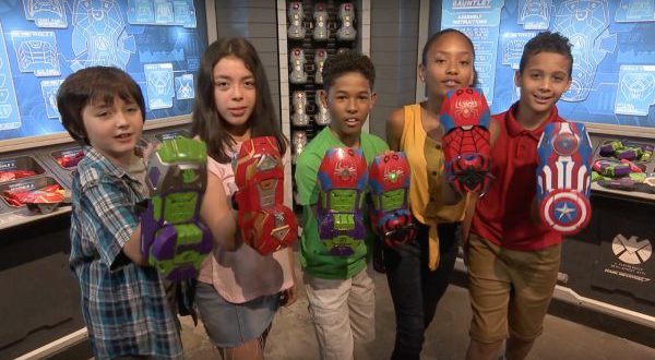 Young heroes show off Super Hero Gauntlets at Disney Springs, surrounded by Marvel gear for the ultimate fan experience.