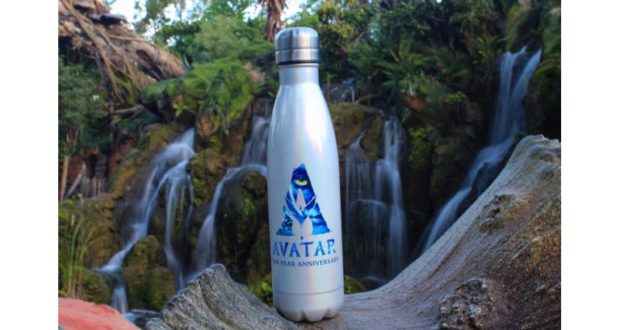 The exclusive Avatar water bottle, featuring the official logo, displayed on a rock amid Pandora’s lush waterfall and greenery.