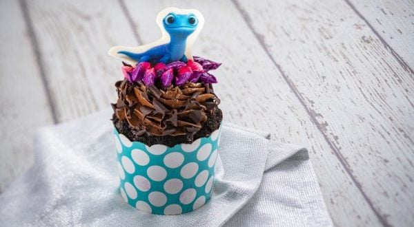 Frozen 2 cupcake at Epcot: chocolate frosting, purple sprinkles, blue lizard topper, blue polka-dot wrapper.