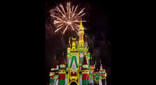 Dazzling fireworks burst over Cinderella Castle, illuminating the sky during Minnie's Wonderful Christmastime Fireworks at Disney World.