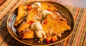 Enjoy fluffy French toast with whipped cream, strawberries, and almonds at Sanaa—an Insta-worthy Disney World breakfast.
