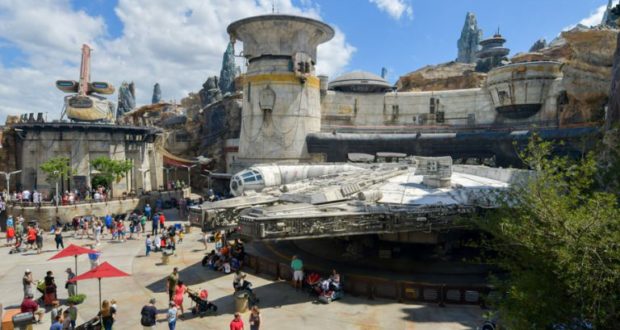 Fans flock around the full-size Millennium Falcon at Star Wars: Galaxy’s Edge, captured by a Super Zoom Magic Shot under blue skies.