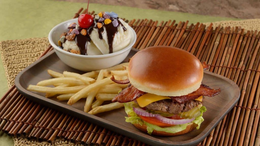 Dig into a Disney Parks classic: bacon cheeseburger, crispy fries, and ice cream with chocolate syrup and cherry on one tray.