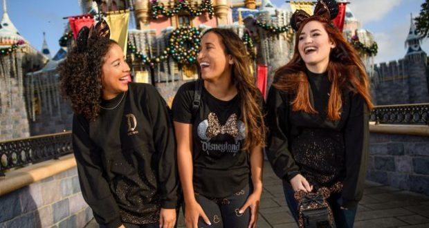 Guests showcase the Belle of the Ball Bronze Disney Parks collection, laughing near Sleeping Beauty Castle at Disneyland.