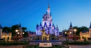 Cinderella Castle glowing at dusk, with Walt Disney and Mickey Mouse statue in front during DisneyParksLIVE’s Super Bowl celebration.