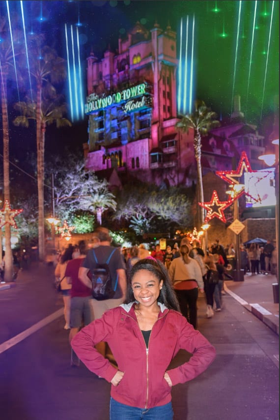 A guest beams in front of the glowing Hollywood Tower Hotel at Disney’s Hollywood Studios, highlighting a must-snap nighttime moment.