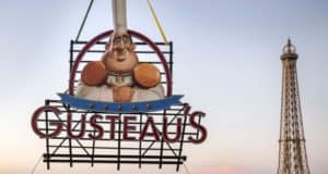 Gusteau’s neon chef sign lights up the evening at Epcot’s France Pavilion, with the Eiffel Tower in the background.