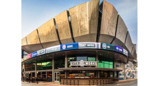 Sleek arena with striking metal panels and vibrant event screens above City Works at Disney Springs, perfect for entertainment fans.