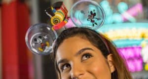 Guest beaming at Disney’s Hollywood Studios in Mickey & Minnie’s Runaway Railway ears, styled with a toy train and Mickey icons.