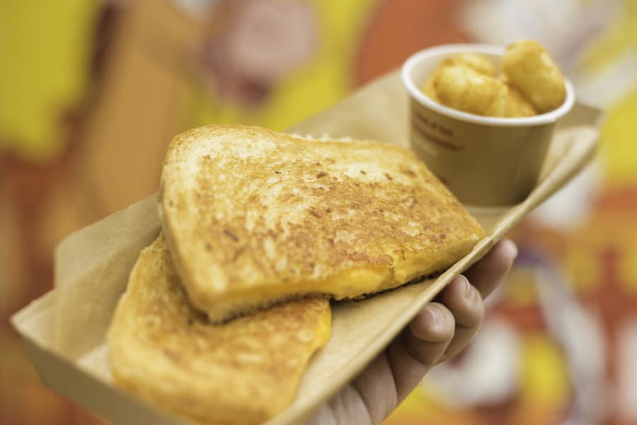 Classic Toy Story Land vibes with a tray of gooey Grilled Cheese and crispy tater tots ready for your Disney park adventure.
