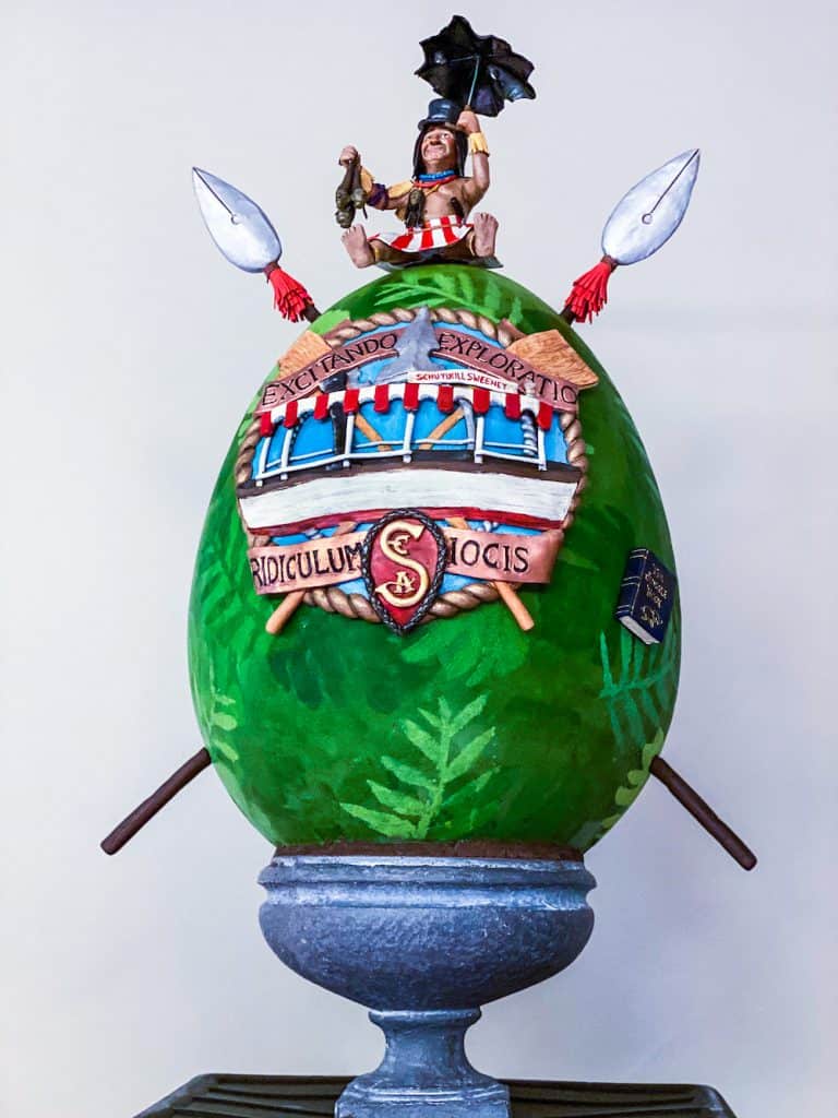 Walt Disney World Easter Egg Display featuring a vibrant green egg with Roman motifs and a Roman figure holding an umbrella on top.