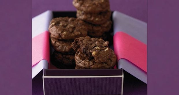 Ghirardelli double chocolate nut cookies stacked in a festive box with pink and purple paper, perfect for a Disney treat stand.