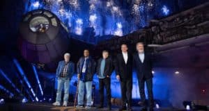 Guests pose in front of the Millennium Falcon at Galaxy’s Edge as fireworks illuminate the night sky at Disneyland Resort.