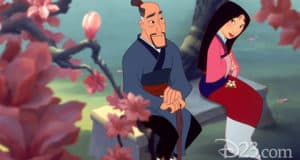 Mulan and her father share a touching moment on a stone bench beneath Disney Parks’ cherry blossoms, capturing classic family magic.