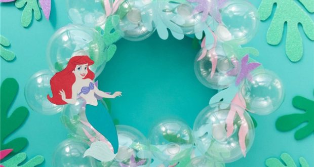 Ariel from The Little Mermaid highlights a whimsical bubble wreath with paper seaweed, perfect for Disney fans, on a teal backdrop.
