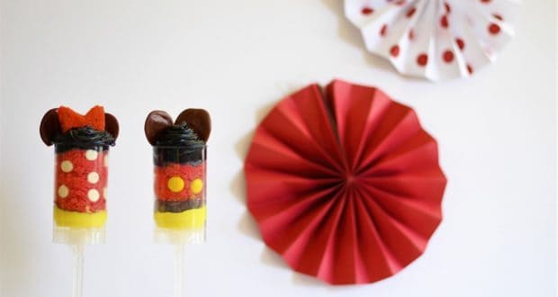 Minnie and Mickey Mouse Cake Push Pops, designed with whimsical Disney flair, displayed before festive red and white paper fans.