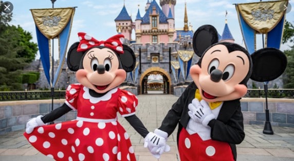 Minnie and Mickey Mouse hold hands before a magical castle, embodying the unforgettable joy of your Disneyland adventure.