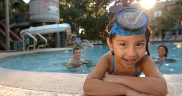 Excited young guest in blue Mickey Mouse goggles enjoys the pool at Disney Beach Resorts; grand opening June 15, join the fun!.