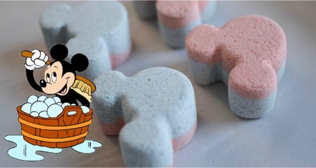 Pink and blue Mickey bath bombs glow beside a cartoon of Mickey Mouse with bubbles, capturing Disney magic for DIY bath fun.