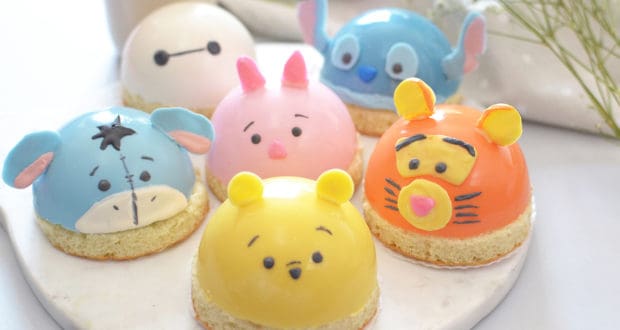 Six Disney character dome cakes line a marble platter, capturing theme park magic in every bite—perfect for any fan celebration.