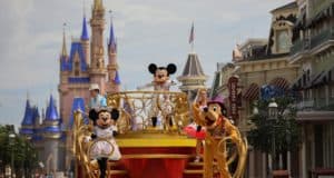 Mickey, Minnie, and Pluto wave from a colorful parade float with Cinderella Castle in the background at Walt Disney World.