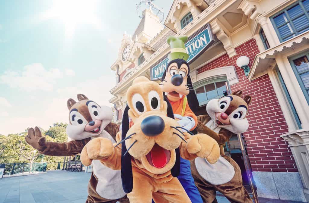 Pluto, Goofy, Chip, and Dale beam in front of Main Street Station—an iconic photo op for International Dog Day at Disney Parks!.