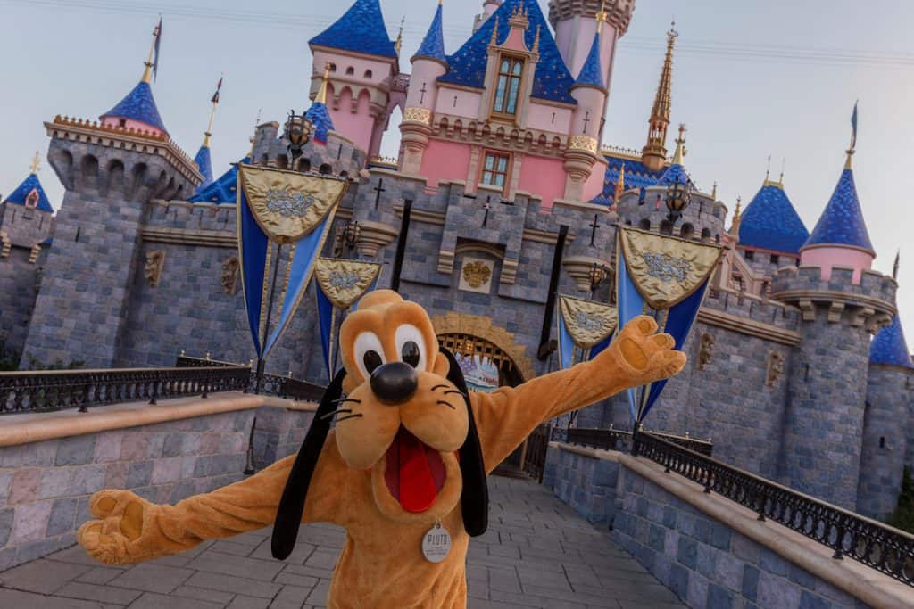 Pluto greets fans with open arms in front of Sleeping Beauty Castle at Disneyland, the ultimate photo op for International Dog Day!.