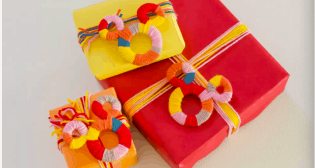 Three vibrant gift boxes with yarn-wrapped rings and festive string accents are displayed on a bright surface, each topped with charming Mickey Mouse yarn figures reminiscent of magical Disney parks, adding a playful touch perfect for any fan’s DIY gift topper collection.