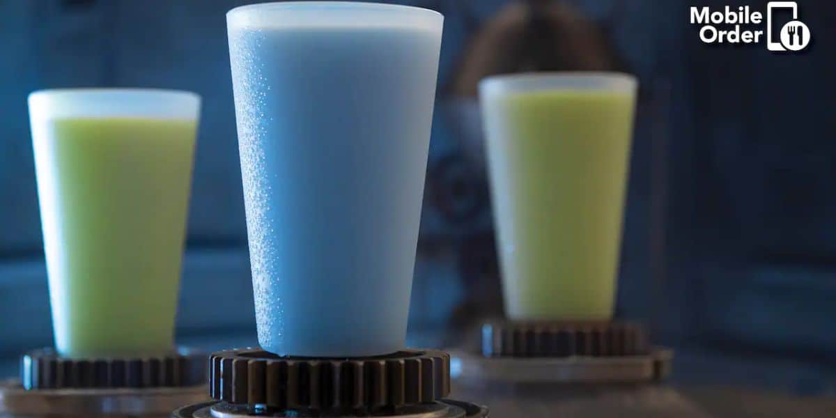 Three futuristic-looking cups of colorful drinks, with the front one in blue and two in green and yellow shades in the background. The setup includes a high-tech vibe and a "Mobile Order" logo in the top right corner.