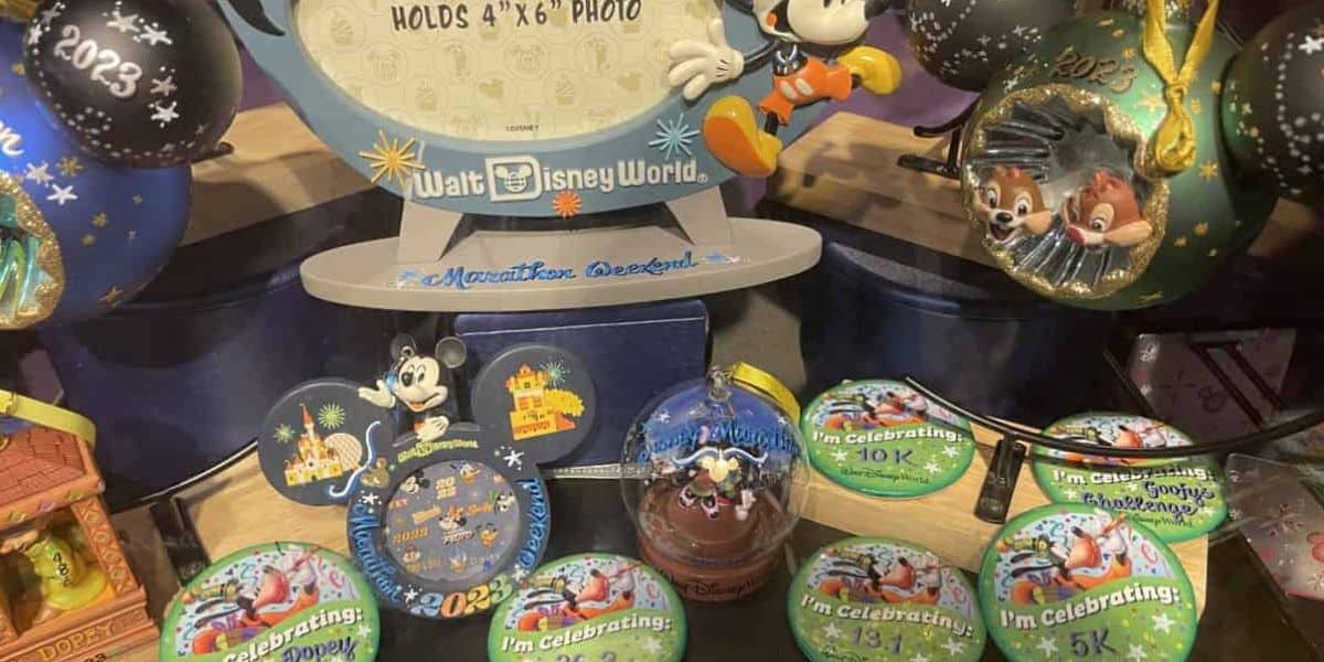 A display of Disney-themed ornaments and medals, including figurines of Mickey Mouse and Chip 'n' Dale. Items feature colorful designs, celebrating incremental distances with numbers like "10K" and "5K," and a photo frame celebrating Walt Disney World.