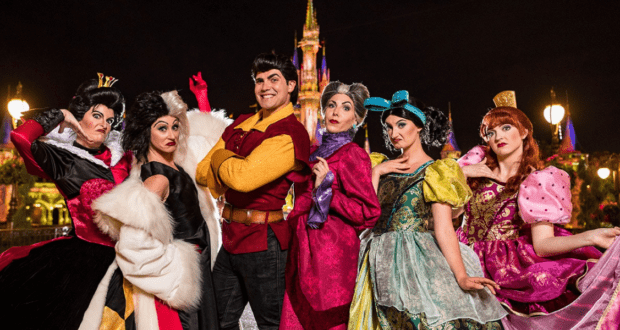 Various Disney villains in front of Cinderella Castle at night