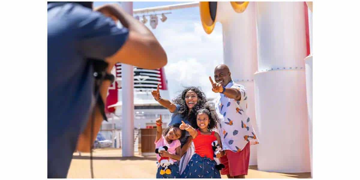 Guests posing for a photographer with DisneyBand+ on Disney Cruise Line