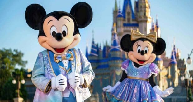 Mickey and Minnie mouse standing in front of cinderella castle
