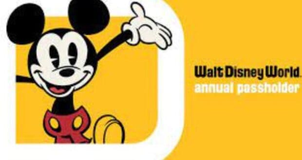 Illustration of Mickey Mouse waving against a yellow background, with the text "Disney Annual Passholder." Mickey sports his classic red shorts and beams with a cheerful expression, capturing the magic of Walt Disney World.