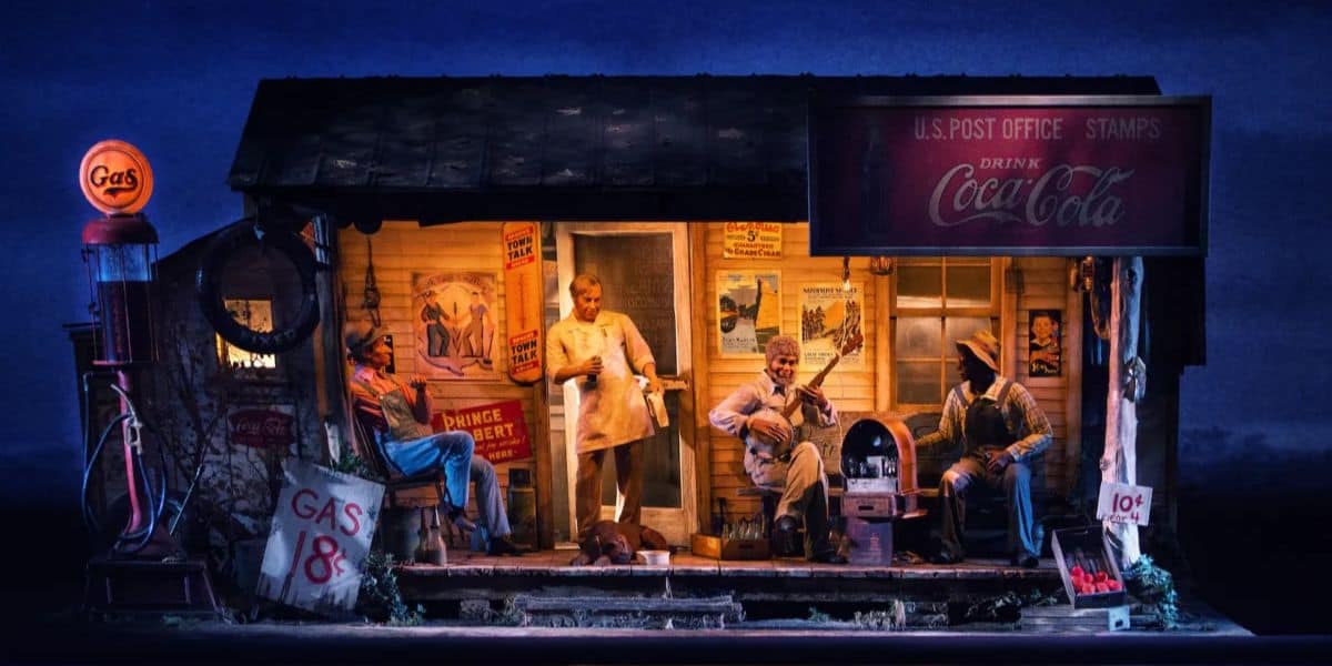 A vintage scene depicts a small gas station/store at night with an illuminated gas sign. People are sitting on the porch: one playing guitar, one on a stool, and another in a chef's uniform. An old Coca-Cola sign is visible, along with various other vintage advertisements. It's like stepping into Americana at Disney World.