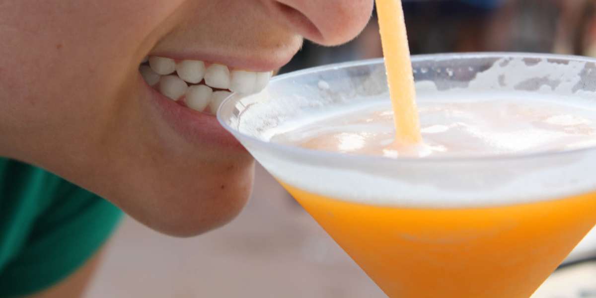 A woman drinking a cold alcoholic drink at EPCOT