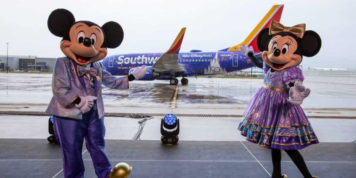 Mickey and Minnie standing in front of a Southwest Plane