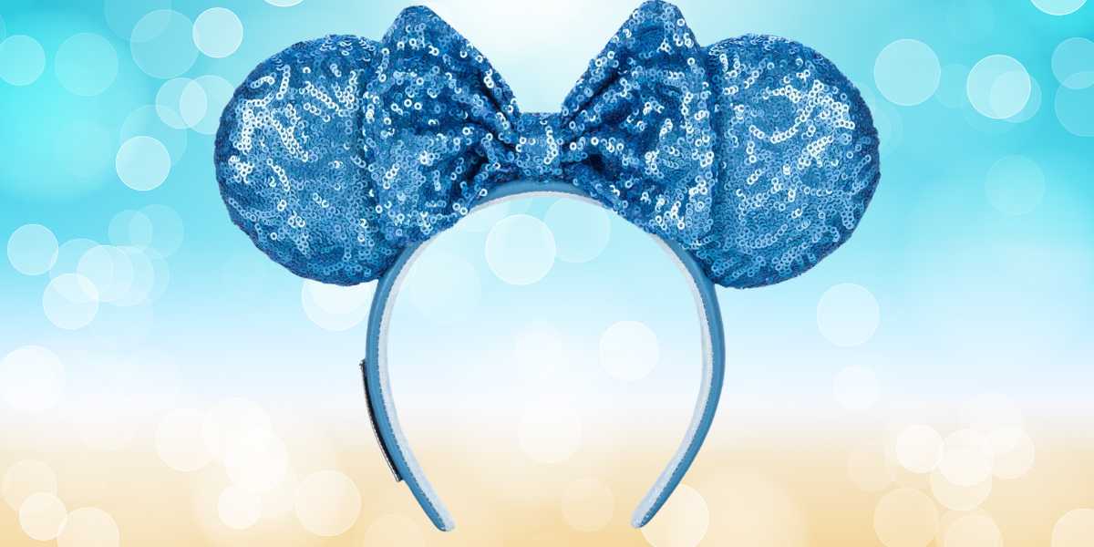 A headband with sparkly blue sequin mouse ears and a matching bow is centered against a blurred light blue and white background, perfect for your next Disney giveaway.