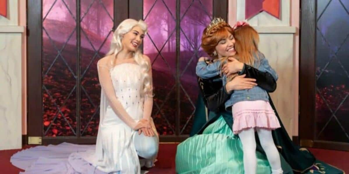 Disney Princesses anna and elsa hug a child at disneyland