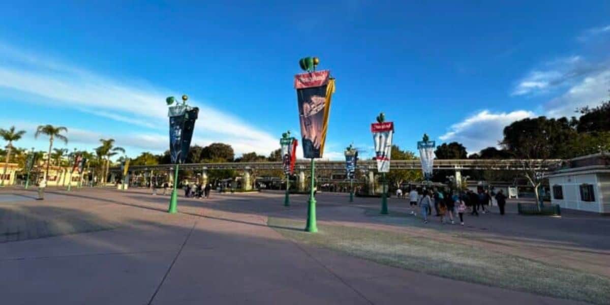 The Disneyland Resort esplanade that guests park hopping walk through, looking toward Disneyland Park, with banners of different Disney movies and attractions